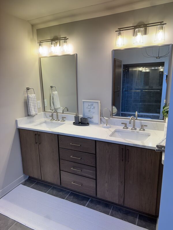 Bathroom double vanity with dark cabinetry and quartz countertop