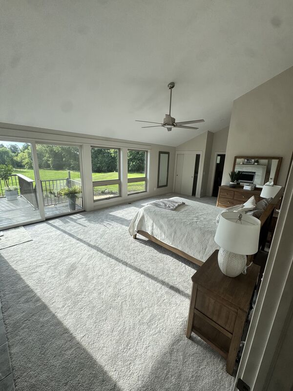 Master bedroom with a wall of windows overlooking the backyard
