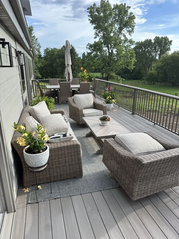 Composite deck with wicker outdoor furniture overlooking green space
