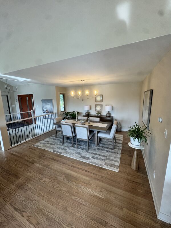 Dining area with a large table over hardwood floors and an area rug