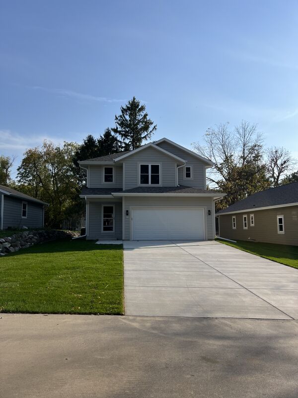 Two-story custom home exterior with attached garage and manicured lawn