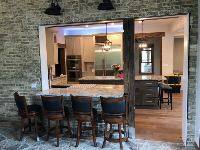 Rustic kitchen bar with stone surround and blue leather barstools