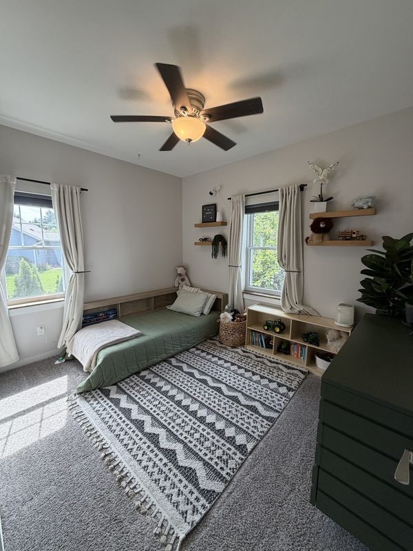 Bright vaulted bedroom with large windows and layered decor