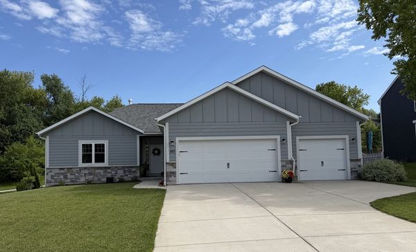 Custom home front elevation with stone accents, board-and-batten and three-car garage