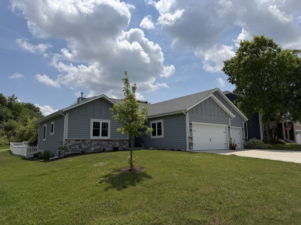 Custom ranch home exterior with attached garage and manicured lawn