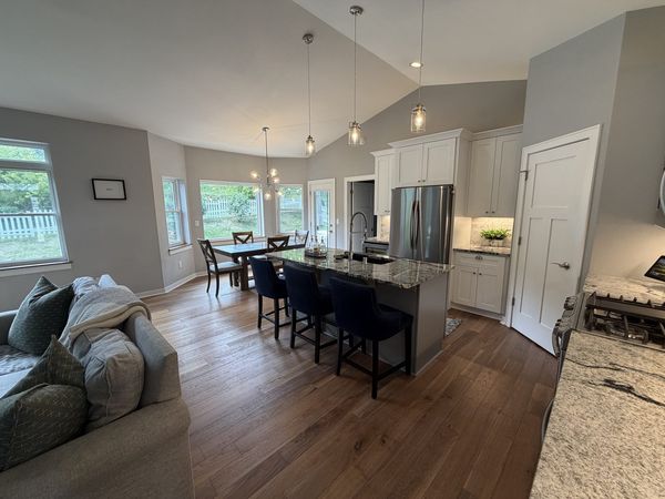 Open-concept great room and kitchen with vaulted ceiling and hardwood floors